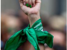 Fist in air with green bandana wrapped around wrist 